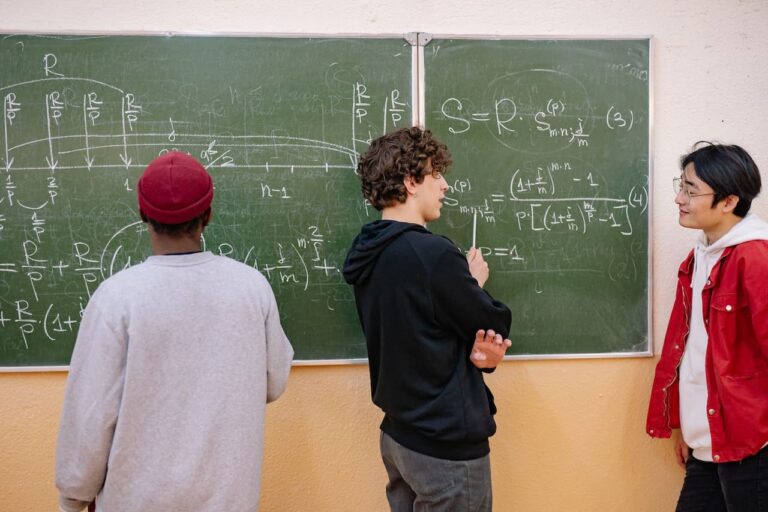 Un grupo de adolescentes resolviendo un problema matemático delante de un pizarrón verde.