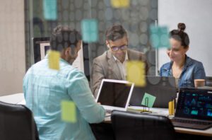 Personas trabajando contentas con tecnología.